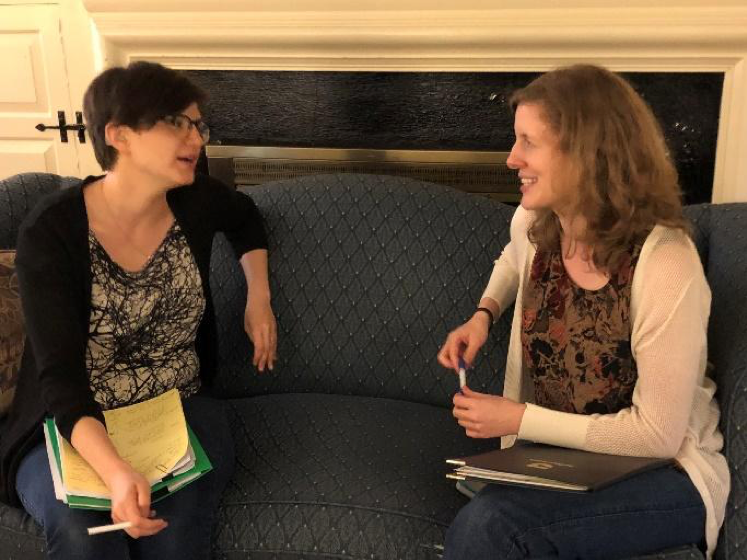 Two women sitting on a couch talking