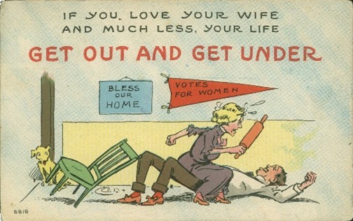 Image is a postcard with the text "if you love your wife and much less your life get out and get under." Underneath the text is a living room with two signs on the wall: "Bless this house" and "votes for women." There is a woman holding a rolling pin menacingly while standing over a man lying on his back on the floor.