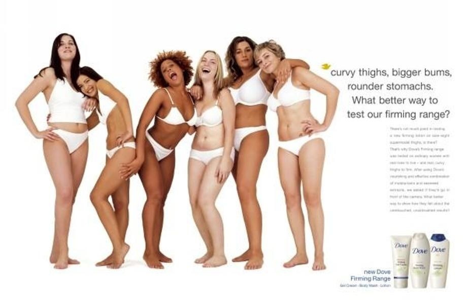 Image is an advertisement from The ‘Dove Real Beauty Pledge. Six racially diverse women are posing together and smiling. Large text to the right of the women reads: "curvy thighs, bigger bums, rounder stomachs. What better way to test our firming range?"