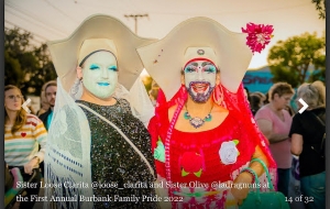 Figure 13. Image description: Sister Unity at Dragcon in 2018 where she spoke on the Sisters’ panel. Photograph of a person in an all-orange costume and elaborate makeup against a light gray background. 