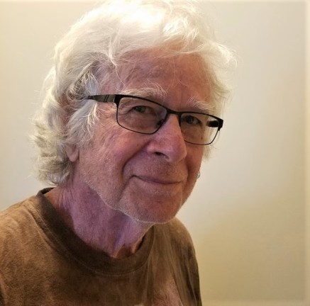 Art Young smiles at the camera and poses in front of a beige background.