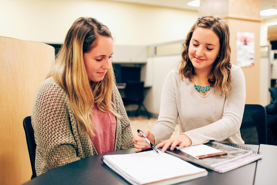 Two James Madison University students, a tutor and a client, discuss an essay during a tutoring session at the writing center.